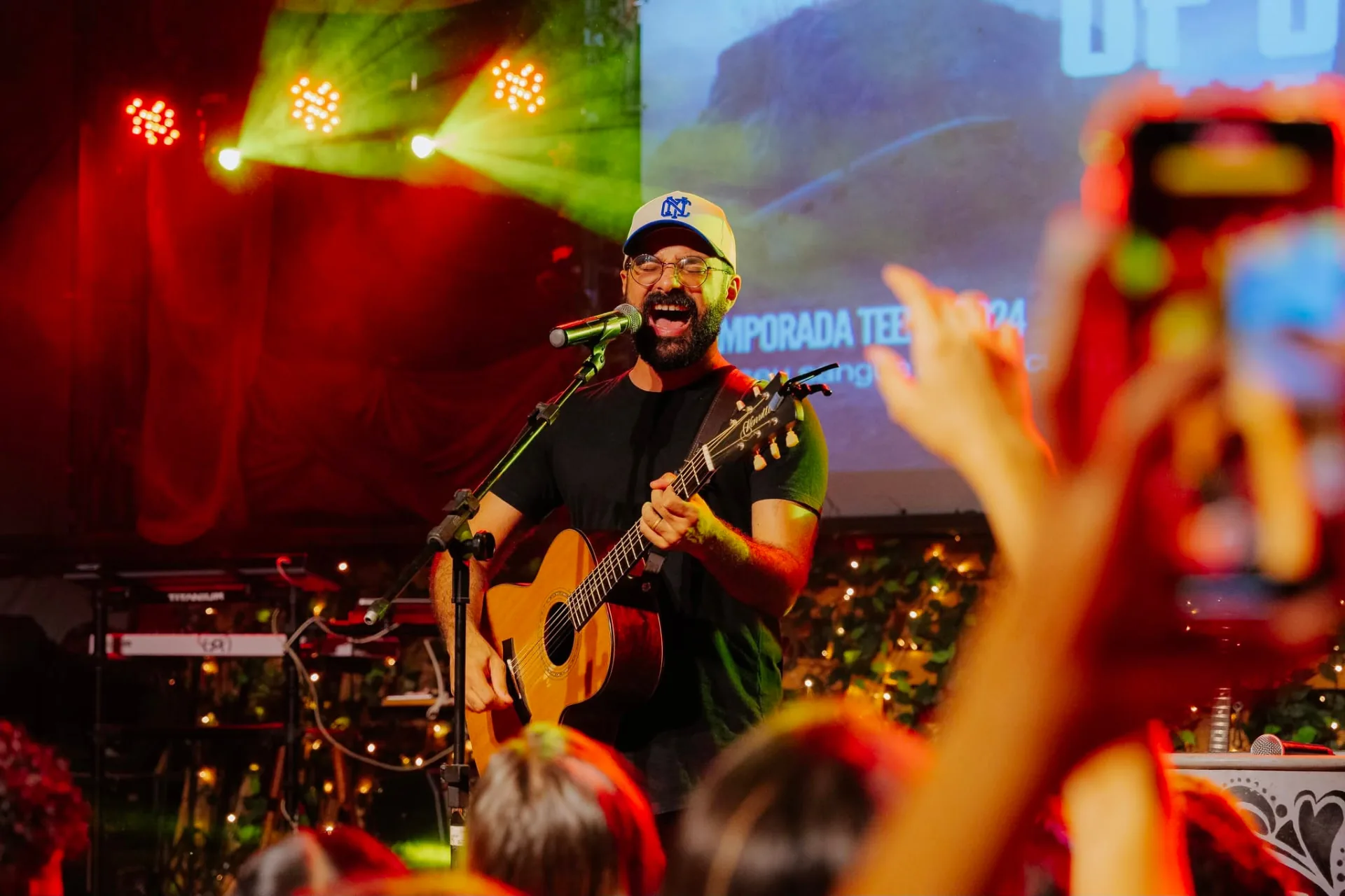 Líder conduzindo um momento de música no palco do Encontro de Líderes