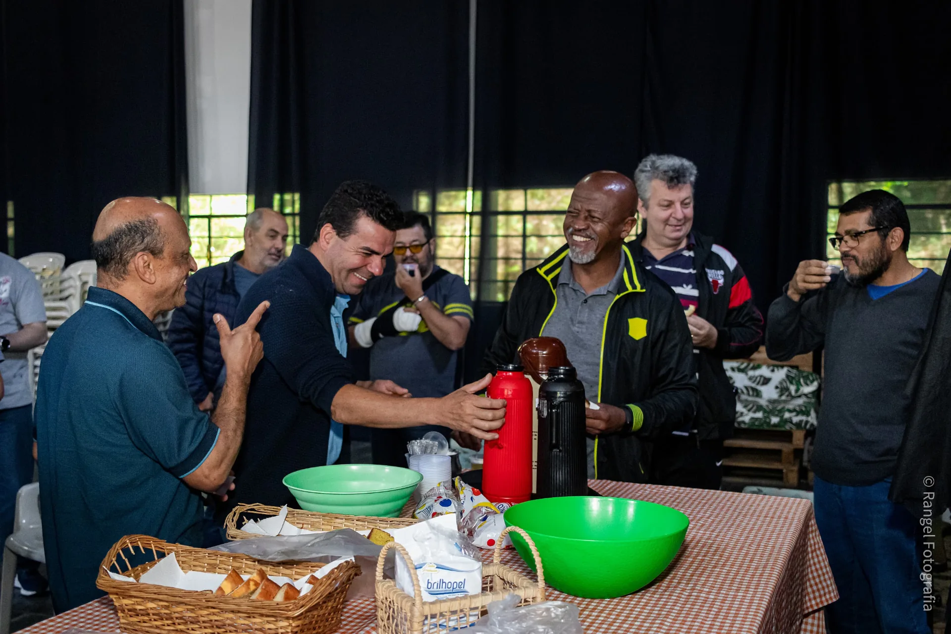 Pastores sorrindo e convivendo ao redor da mesa do café no PAM