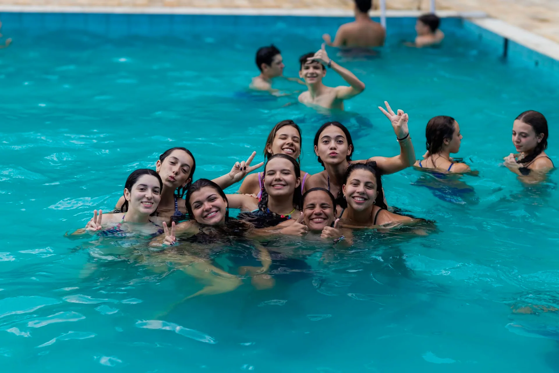 Grupo de adolescentes sorrindo e aproveitando a piscina durante a Temporada Teens