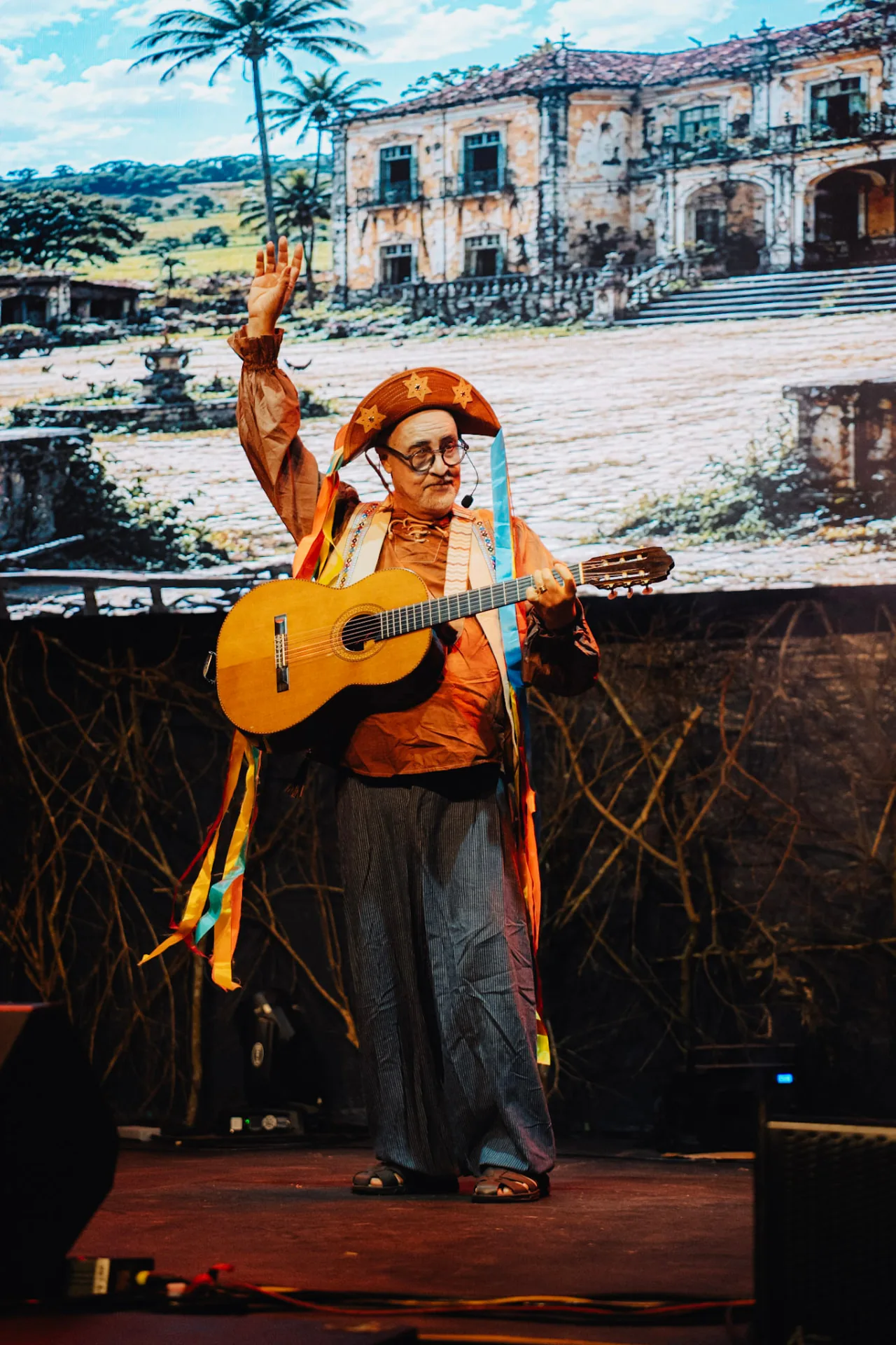 Violeiro com traje regional em apresentação musical brasileira no NMB