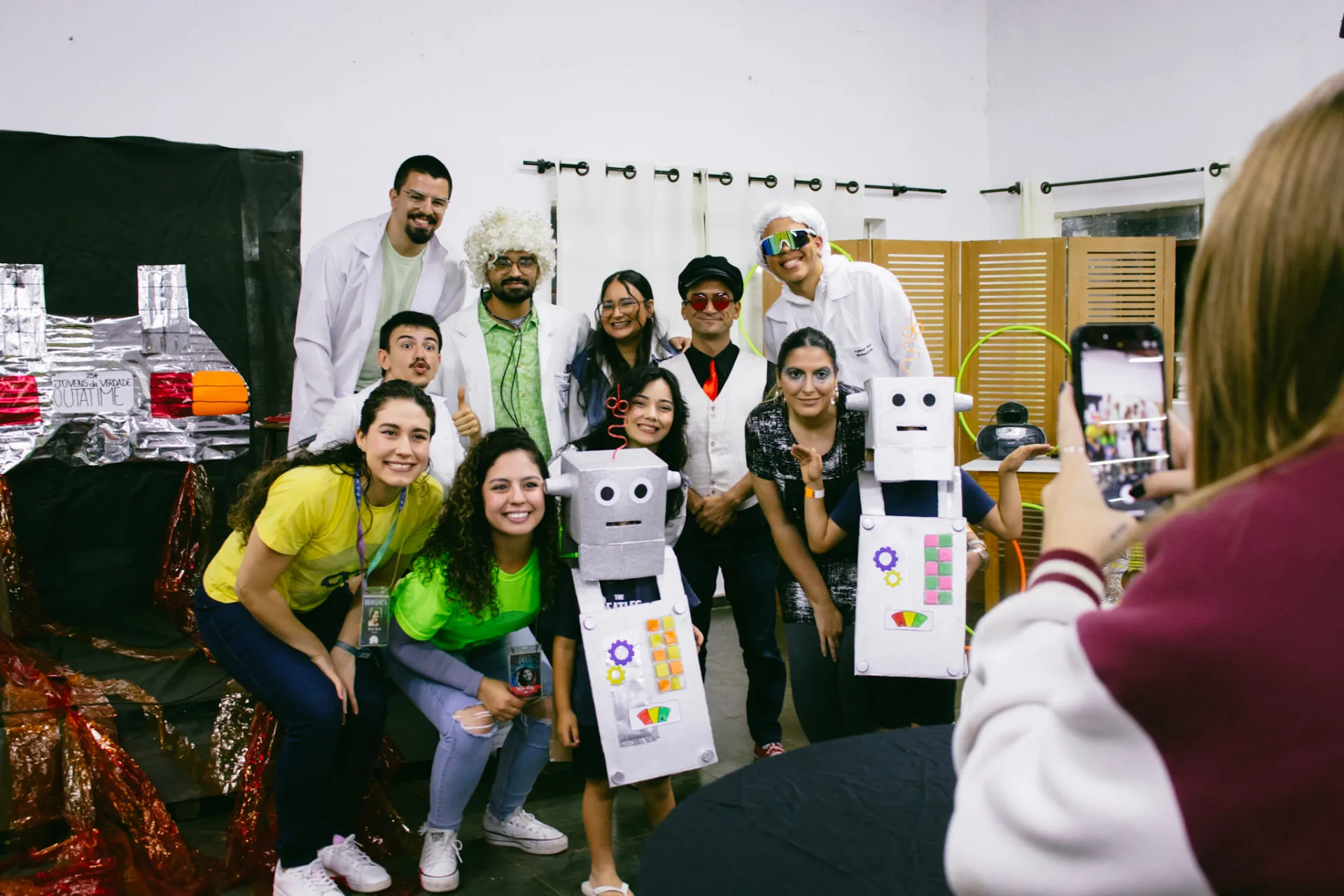 Participantes fantasiados de cientistas e robôs em um jantar temático do Acampa 25+