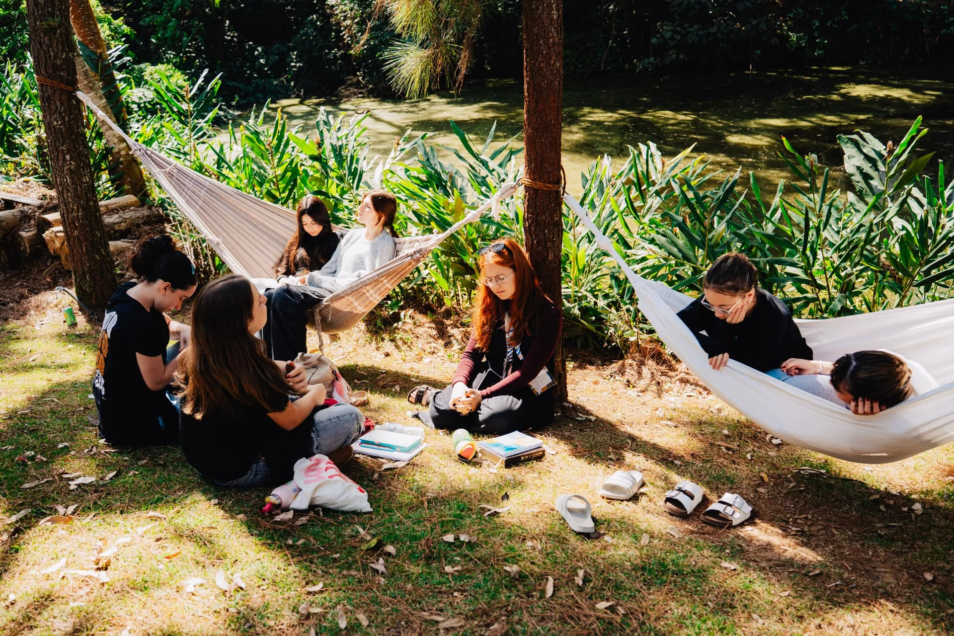 Adolescentes conversando e descansando em redes junto ao lago do Jovens da Verdade