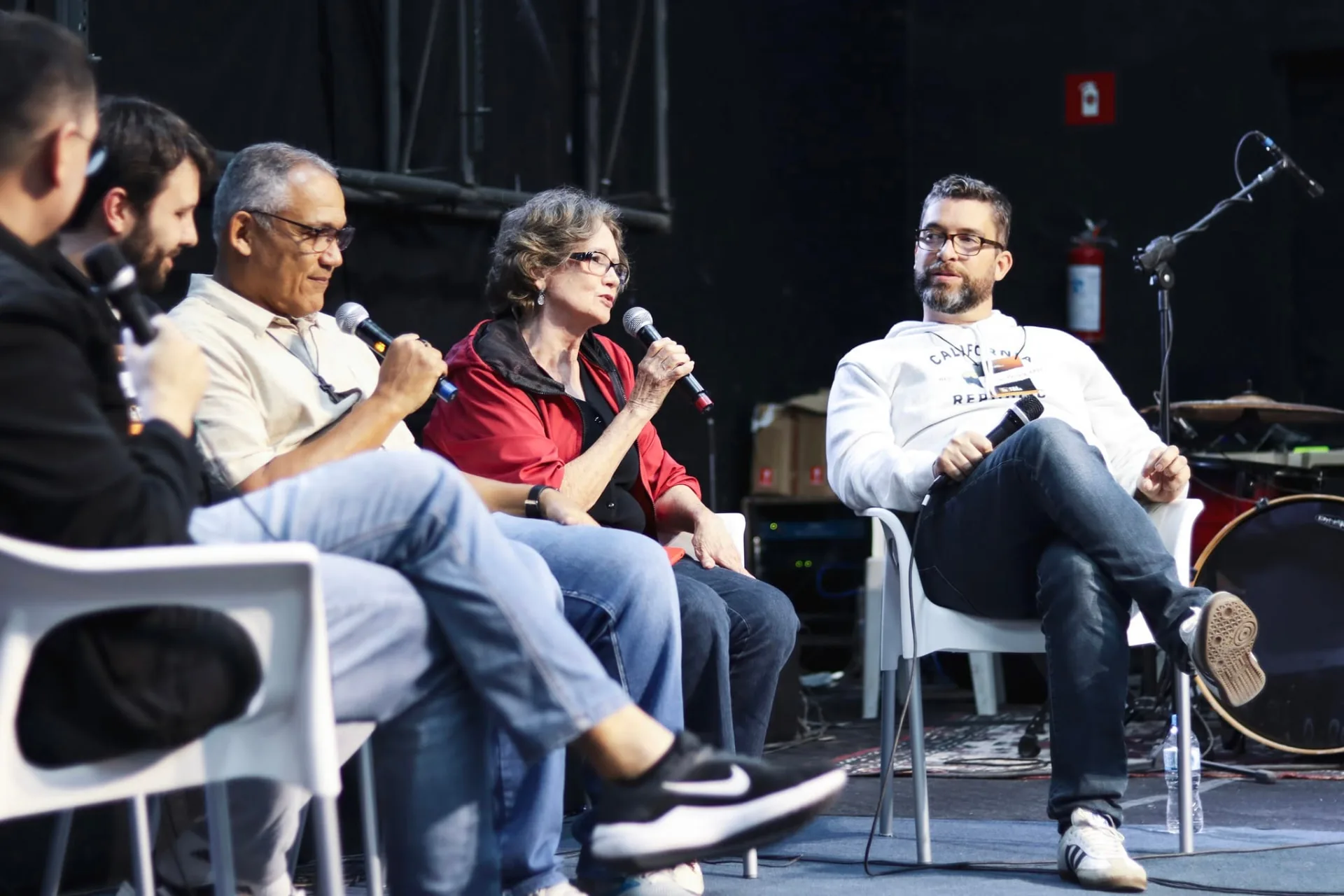 Pastores e líderes conversando em um painel no palco