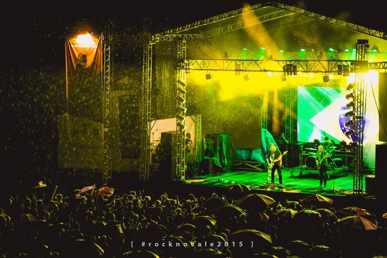 Palco do Rock no Vale sob a chuva diante do público com guarda-chuvas