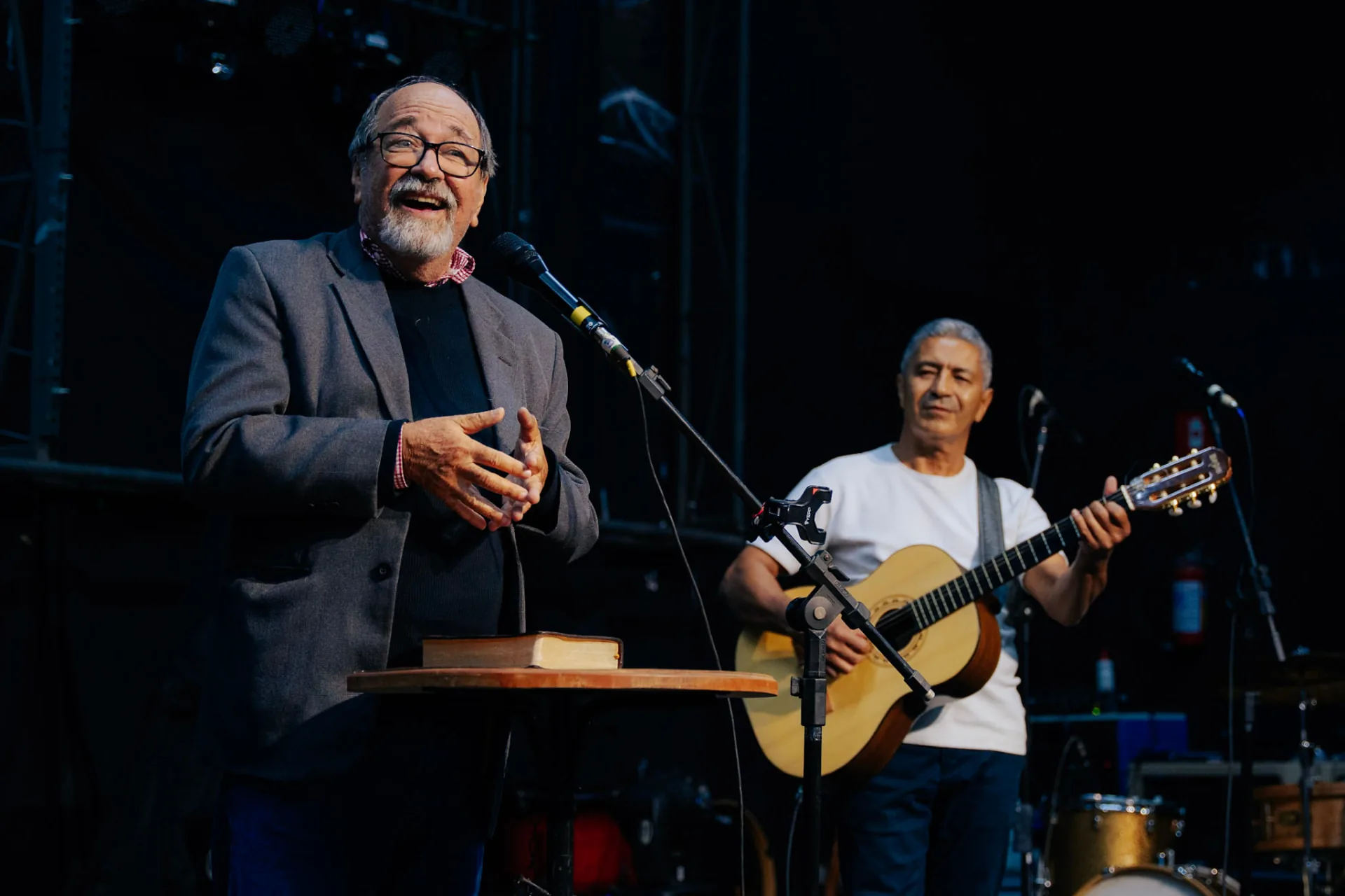 Pregador com a Bíblia e músico durante uma mensagem no Acampa 50+