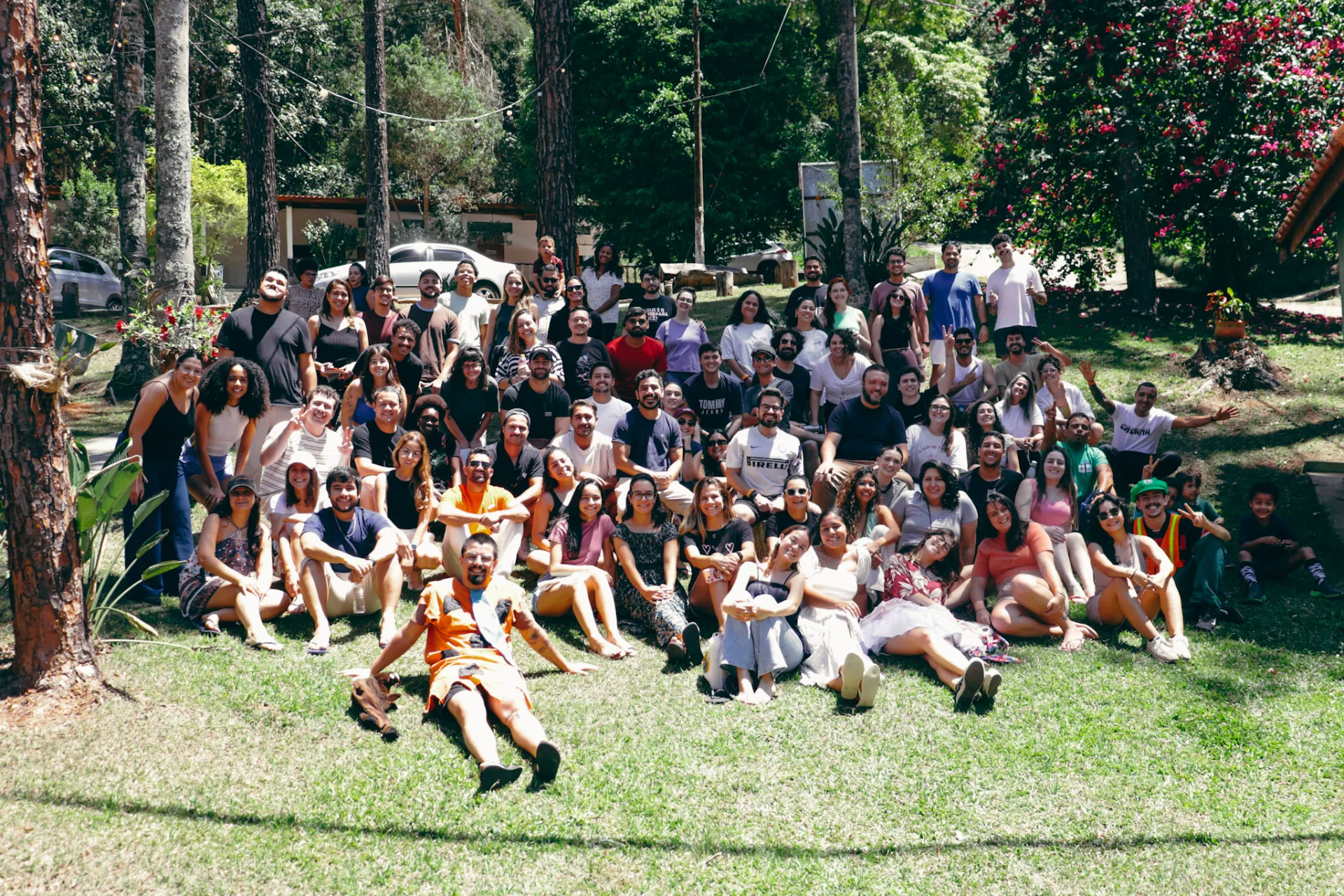 Grande grupo de participantes reunido em uma área verde no encerramento do Acampa 25+